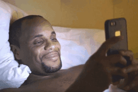 Man Smiles at His Phone Late at Night